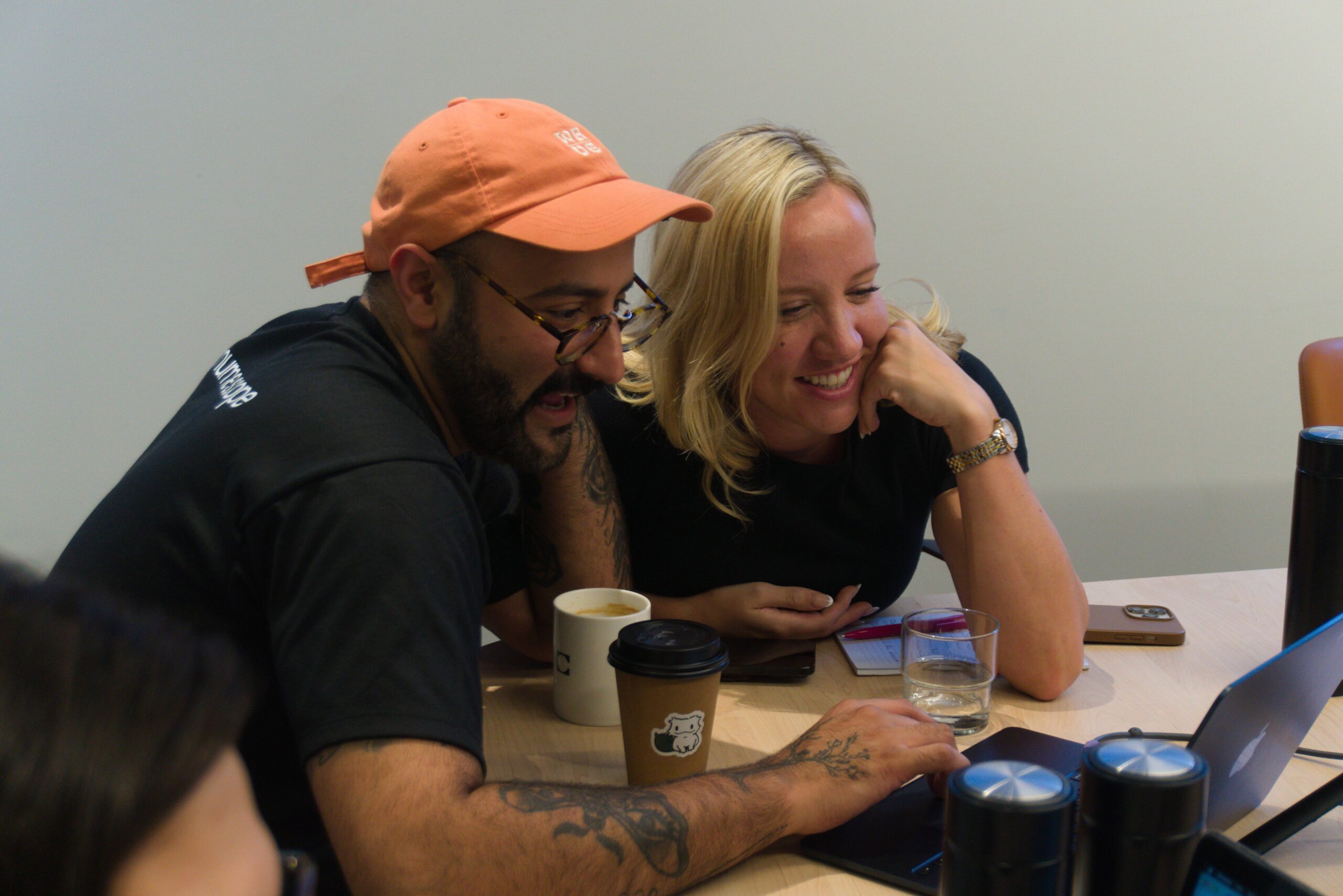 Ez leaning in with a client, looking at a laptop together